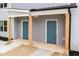 Inviting front entrance featuring two teal doors with natural wood supports under a shared porch at 1047 |1049 E Harnett St, Dunn, NC 28334