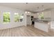 Well-lit kitchen featuring white cabinets, granite countertops, modern appliances and wood-look floors at 1047 |1049 E Harnett St, Dunn, NC 28334