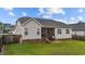Well-kept backyard featuring a screened porch, patio area, and mature trees at 105 Jasper Creek Ct, Wilson's Mills, NC 27520