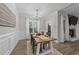 Inviting dining room with a rustic table, wainscoting, and bright natural light at 105 Jasper Creek Ct, Wilson's Mills, NC 27520