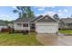 Charming home with a two-car garage, covered porch, and well-manicured lawn and shrubbery at 105 Jasper Creek Ct, Wilson's Mills, NC 27520