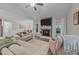 Inviting living room showcases a stone fireplace and an open view into the dining and kitchen areas at 105 Jasper Creek Ct, Wilson's Mills, NC 27520