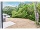 A leveled backyard offers a serene setting with mature trees and natural landscaping at 1057 |1059 E Harnett St, Dunn, NC 28334