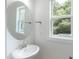 Bathroom features a modern sink, mirror, and bright window with backyard tree views at 1057 |1059 E Harnett St, Dunn, NC 28334
