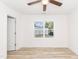 A bright bedroom has a ceiling fan, wood-look floors, and a large window that fills the room with sunlight at 1057 |1059 E Harnett St, Dunn, NC 28334