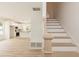 Bright entryway with light wood floors, stairs, and built-in storage leading to an open-concept kitchen at 1057 |1059 E Harnett St, Dunn, NC 28334