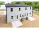 Back exterior of a two story home with light gray siding and windows with back patios at 1057 |1059 E Harnett St, Dunn, NC 28334