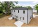 Back exterior of a two story home with light gray siding and windows with back patios at 1057 |1059 E Harnett St, Dunn, NC 28334
