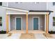 New construction building featuring two separate units each with a teal front door and wooden pillar supports at 1057 |1059 E Harnett St, Dunn, NC 28334