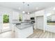 Well-lit kitchen featuring white cabinets, granite countertops and stainless appliances, plus an island at 1057 |1059 E Harnett St, Dunn, NC 28334