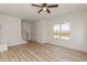 Bright living room featuring light wood floors, white walls, ceiling fan, stairs and built-in storage at 1057 |1059 E Harnett St, Dunn, NC 28334