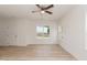 Bright living room featuring light wood floors, white walls, ceiling fan, and windows at 1057 |1059 E Harnett St, Dunn, NC 28334