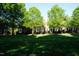 Well-maintained townhouses surrounded by mature trees and lush green lawns in a tranquil setting at 108 W Savannah Ridge Rd, Holly Springs, NC 27540