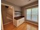 Dining room with hardwood floors, cabinet with dark counter, floating shelves and large window at 108 W Savannah Ridge Rd, Holly Springs, NC 27540