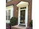 Elegant front door with glass panes and sidelights, framed by manicured greenery at 108 W Savannah Ridge Rd, Holly Springs, NC 27540