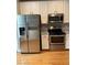 Bright kitchen featuring stainless steel appliances, white cabinetry, and subway tile backsplash at 108 W Savannah Ridge Rd, Holly Springs, NC 27540
