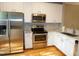 Modern kitchen with stainless steel appliances, white cabinets, and stylish countertops at 108 W Savannah Ridge Rd, Holly Springs, NC 27540