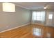 Open living room with hardwood floors, modern lighting, and large windows at 108 W Savannah Ridge Rd, Holly Springs, NC 27540