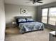This bedroom features plush carpet, a ceiling fan, and a large window for natural light at 1129 Kudzu St, Durham, NC 27713