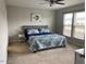 This bedroom features plush carpet, a ceiling fan, and a large window for natural light at 1129 Kudzu St, Durham, NC 27713