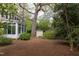 Backyard featuring green space, garden shed, mature trees, and covered porch at 1208 College Pl, Raleigh, NC 27605
