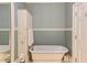 Stylish bathroom with wallpaper, a soaking tub, built-in storage and a mirror at 1208 College Pl, Raleigh, NC 27605