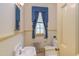 This bathroom features a vintage sink, toilet, radiator, window, and bright blue accent curtain at 1208 College Pl, Raleigh, NC 27605