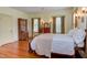Cozy bedroom featuring hardwood floors, a bed with white linens, and vintage wooden furniture at 1208 College Pl, Raleigh, NC 27605