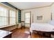 Bright bedroom features a four-poster bed, hardwood floors, built-in shelving, and large windows at 1208 College Pl, Raleigh, NC 27605
