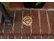 Close-up of decorative tile embedded in red brickwork with a cracked, aged appearance at 1208 College Pl, Raleigh, NC 27605