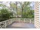View of the home's wooden deck with decorative white railings and view of the surrounding trees and greenery at 1208 College Pl, Raleigh, NC 27605