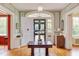 Grand foyer with a view of the front door and lush front yard, complemented by elegant decor and woodwork at 1208 College Pl, Raleigh, NC 27605