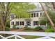 Inviting two-story home with classic yellow siding, black shutters, and a well-manicured front yard with a picket fence at 1208 College Pl, Raleigh, NC 27605