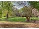 Charming front yard view with mature trees and well-manicured lawn and a home in the background at 1208 College Pl, Raleigh, NC 27605