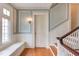 Hallway featuring staircase with wood railing, hardwood floors, wall paneling, and a window seat at 1208 College Pl, Raleigh, NC 27605
