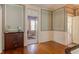 Hallway with hardwood floors, blue walls, white trim, and a view into another room at 1208 College Pl, Raleigh, NC 27605