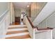Hallway featuring a wood staircase, hardwood floors, and pale blue walls with white trim at 1208 College Pl, Raleigh, NC 27605