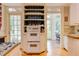 Well-lit kitchen features a double oven, custom shelving and French doors at 1208 College Pl, Raleigh, NC 27605