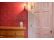 Living room featuring floral wallpaper, wood floors, dresser, and a white door at 1208 College Pl, Raleigh, NC 27605