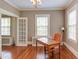 Sunlit office showcasing hardwood floors, french doors, and a vintage chandelier at 1208 College Pl, Raleigh, NC 27605