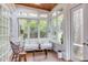 Bright sunroom with wood ceiling, large windows, a white wicker couch, and hardwood floors at 1208 College Pl, Raleigh, NC 27605