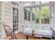 Bright sunroom with white wicker seating, wood floors, and many large windows at 1208 College Pl, Raleigh, NC 27605