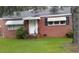 Charming brick home with awnings, a well-manicured lawn, and mature trees at 1210 Cypress St, Rocky Mount, NC 27801