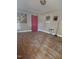 A living room with hardwood floors, artwork, and a window with red curtains at 1210 Cypress St, Rocky Mount, NC 27801