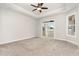 Spacious bedroom showcasing neutral carpet, a ceiling fan, tray ceiling, and access to a screened-in porch at 1217 Linkwood Way, Fuquay Varina, NC 27526