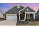 Charming single-Gathering home featuring a stone facade, well-manicured landscaping, and a two-car garage at 1217 Linkwood Way, Fuquay Varina, NC 27526