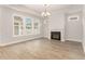 Bright living room featuring a fireplace, hardwood floors, a ceiling fan and large windows for natural light at 1217 Linkwood Way, Fuquay Varina, NC 27526
