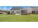 Spacious backyard featuring a well-maintained lawn, screened porch, and partial side view of a house at 153 Tennyson Dr # 235, Garner, NC 27529