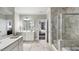 Luxurious bathroom featuring marble floors, double vanities, and a glass-enclosed shower, creating a spa-like retreat at 153 Tennyson Dr # 235, Garner, NC 27529