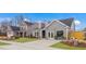 A view of the two-story home with gray siding, dormers, well-manicured lawns, and a concrete driveway at 153 Tennyson Dr # 235, Garner, NC 27529